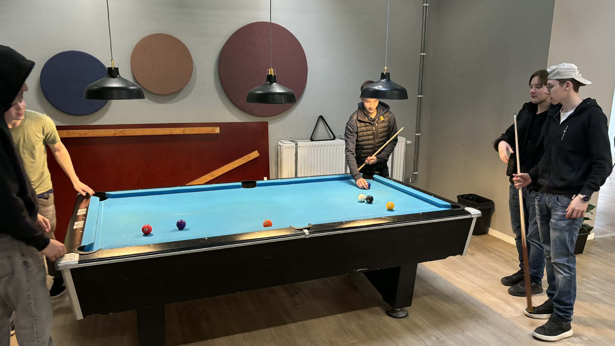 Bilden visar några elever som spelar biljard på caféet.